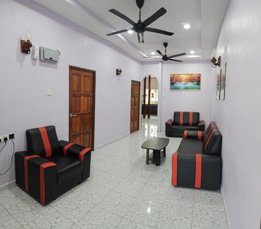 a living room with two chairs and a ceiling fan at Liya's Homestay in Kangar