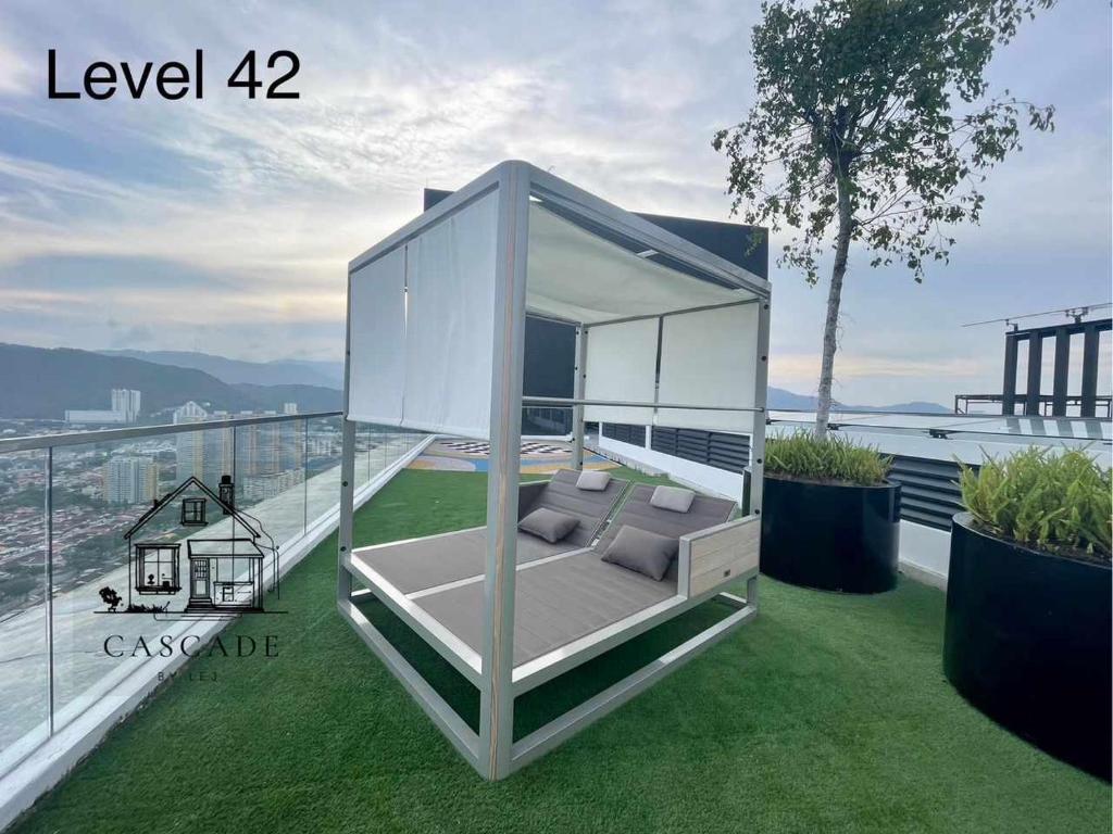 a glass house with a couch on a balcony at Urban Suites Studio #SelfCheck-In #PrivateSpace in Jelutong