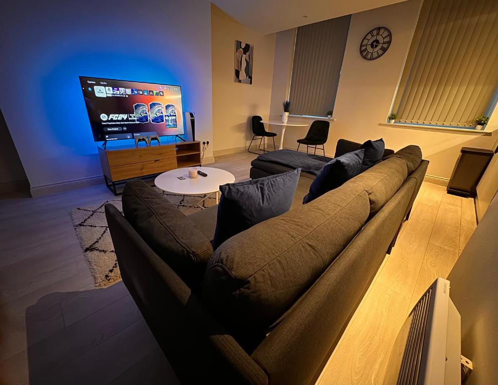 Una sala de estar con un sofá y un televisor de pantalla plana. en Central Leeds - Stylish Apartment, en Leeds