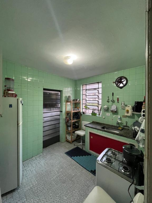 a green kitchen with a stove and a refrigerator at apartamento no centro in Osasco