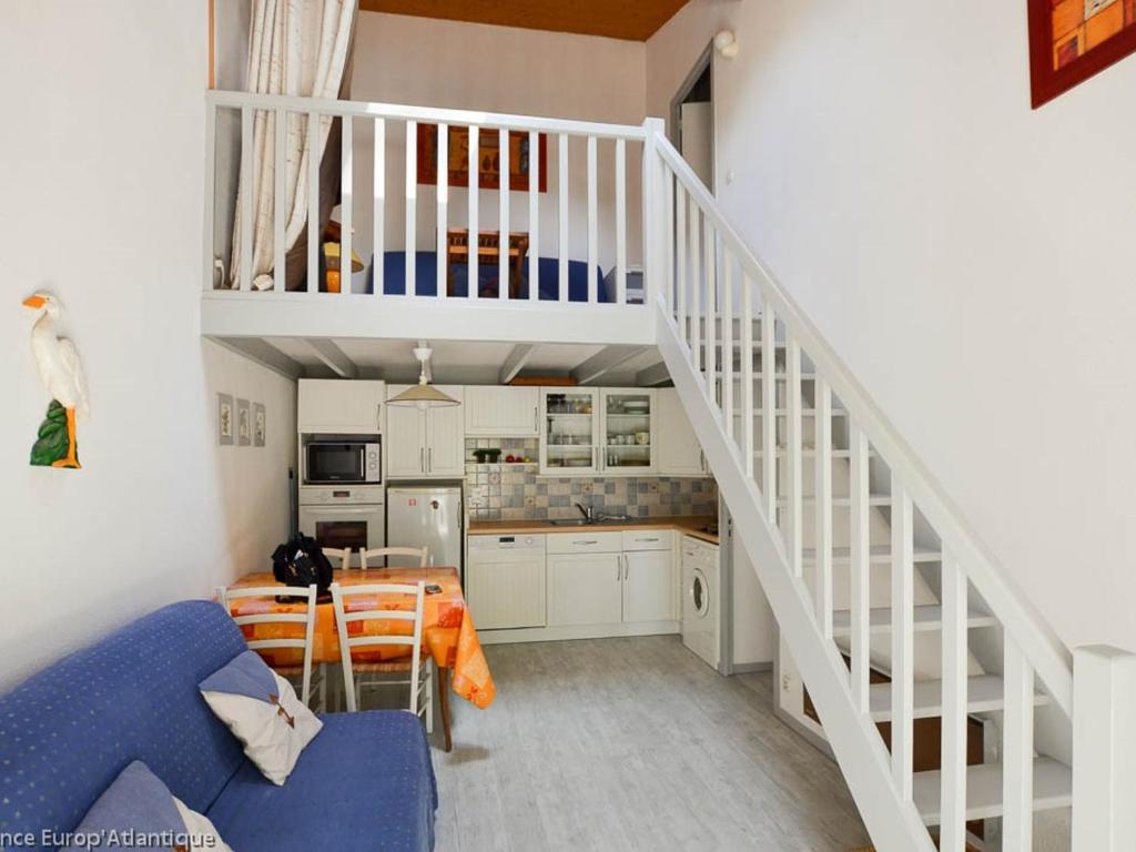 Il comprend une cuisine et un salon avec un canapé bleu. dans l'établissement Maison T3 bis La Palmyre - Terrasse, Wifi, Parking, Proche Mer et Commerces - FR-1-705-80, aux Mathes