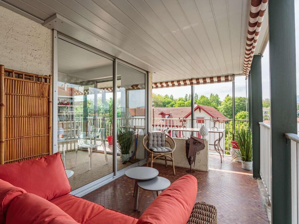 - un salon avec un canapé et une table sur un balcon dans l'établissement Appartement moderne en centre-ville avec balcon et parking à 400m de la plage - FR-1-4-693, à Saint-Jean-de-Luz