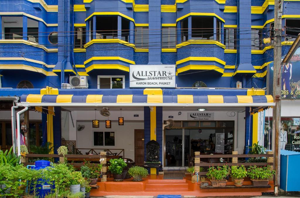 a building with a blue and yellow building at Allstar Guesthouse in Karon Beach