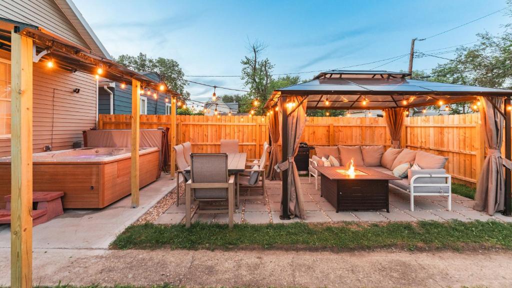 a patio with a couch and a table and a hot tub at 5 mins to Speedway! Walk to Zoo, WR park, IUPUI! in Indianapolis