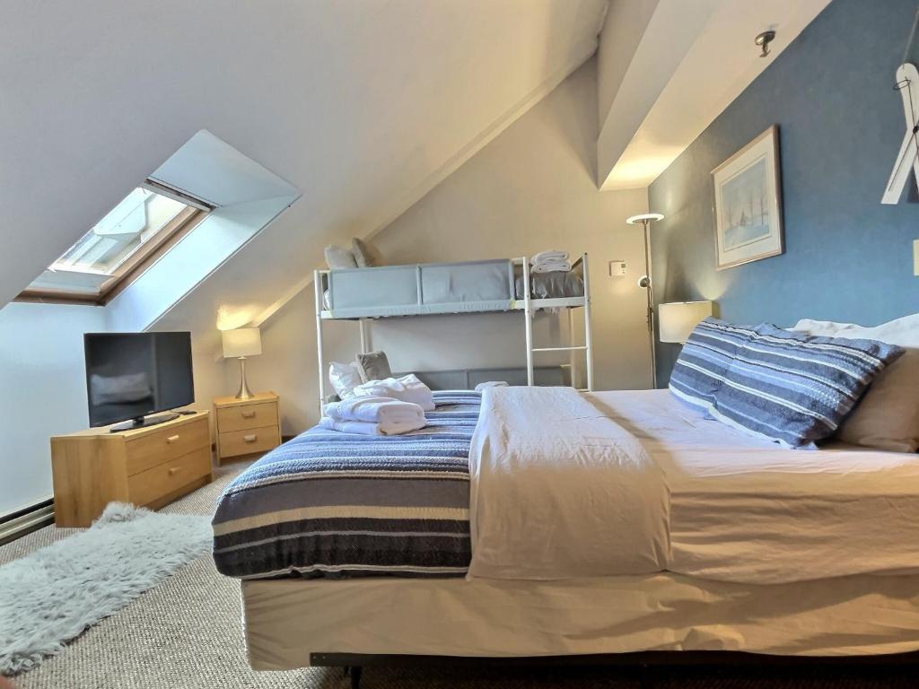 a bedroom with a large bed and a tv at LilBear- AC, Pool, Sauna, Hot Tub, Near Resort in Killington