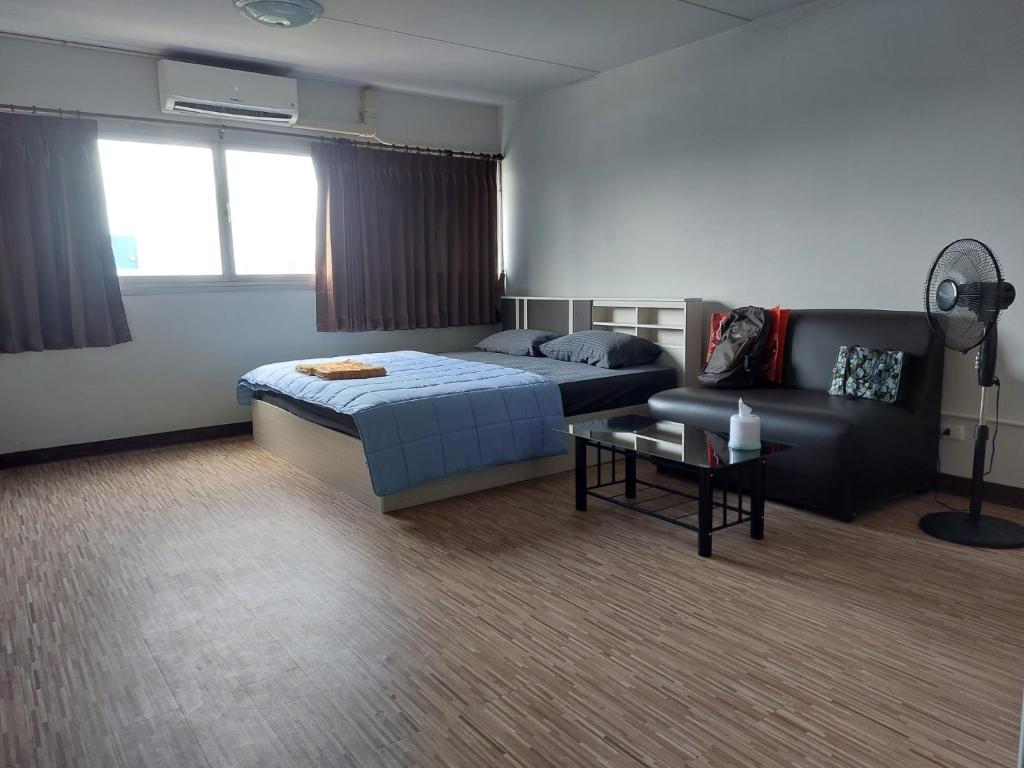 een slaapkamer met een bed en een bank bij Solitude Skies14th Floor Studio in Nonthaburi