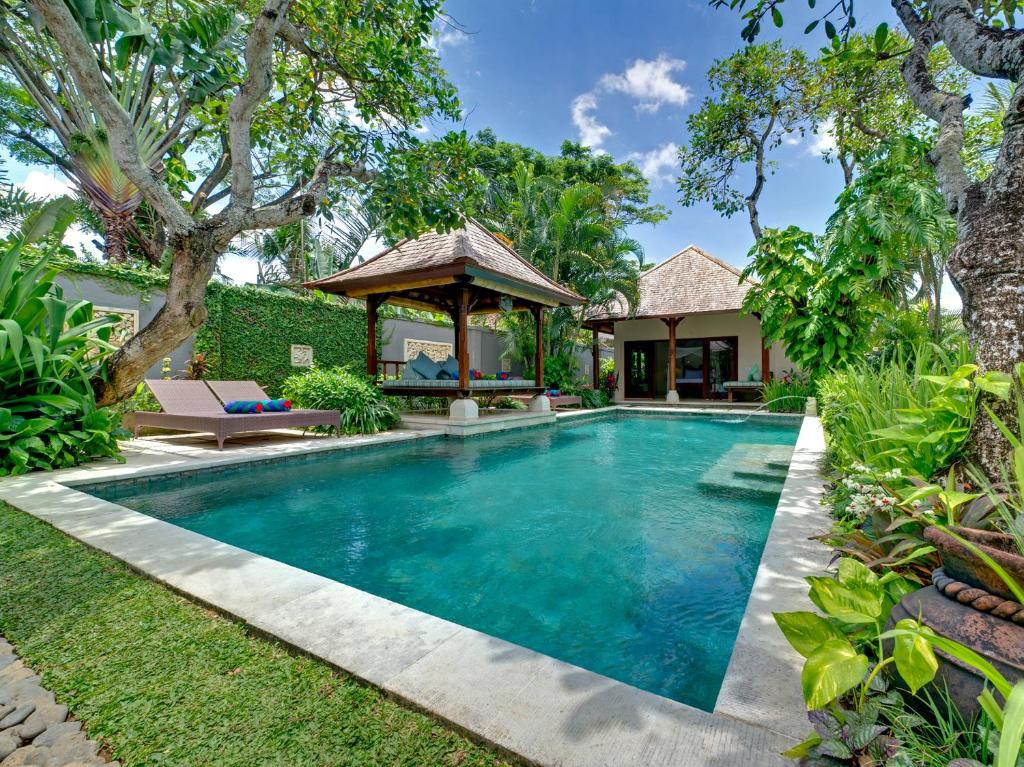 a swimming pool in a backyard with a gazebo at Villa Kedidi in Canggu