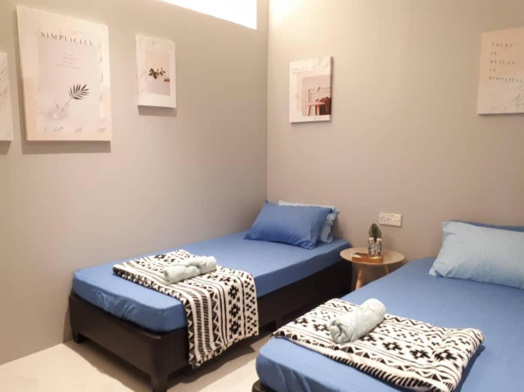 a room with two twin beds and a table at The Village Inn in Raub