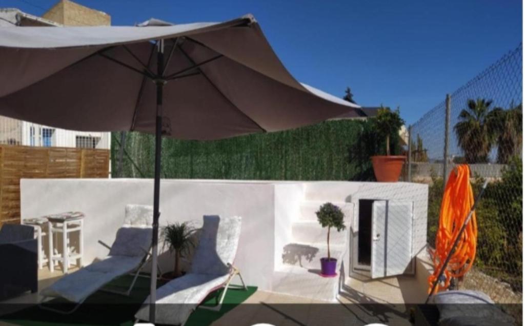 ein Sonnenschirm und einige Stühle in der Unterkunft CASA HUERTA SOFIA in Murcia