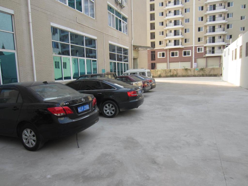 eine Gruppe von Autos, die auf einem Parkplatz geparkt sind in der Unterkunft Jinjiang Inn Xiamen Jimei Xinglin in Xiamen