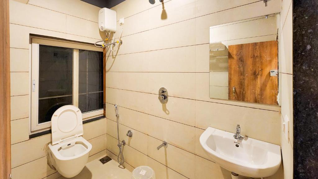 a bathroom with a toilet and a sink at Hotel Nova Shine in Rajkot