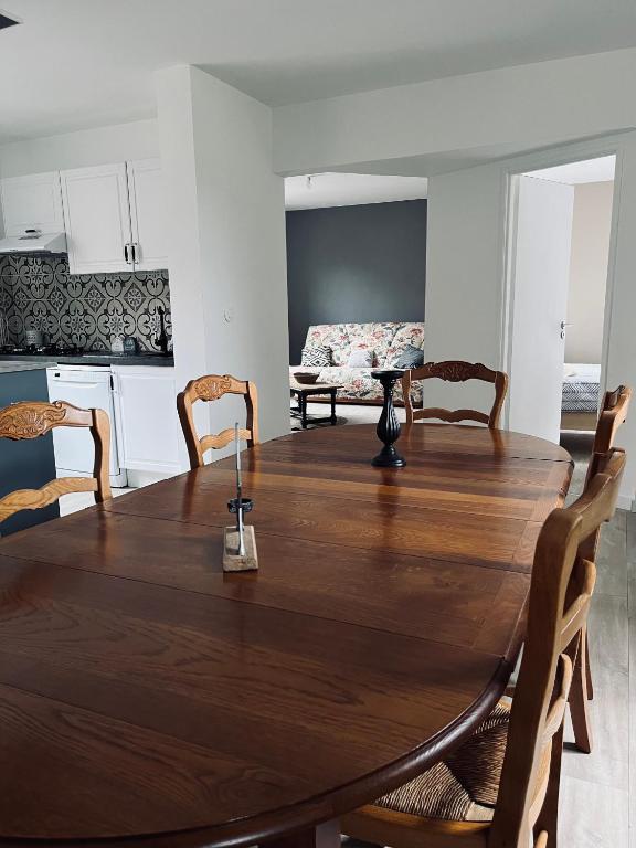 une salle à manger avec une table et des chaises en bois dans l'établissement Grand appartement à la campagne, à Celles-sur-Plaine