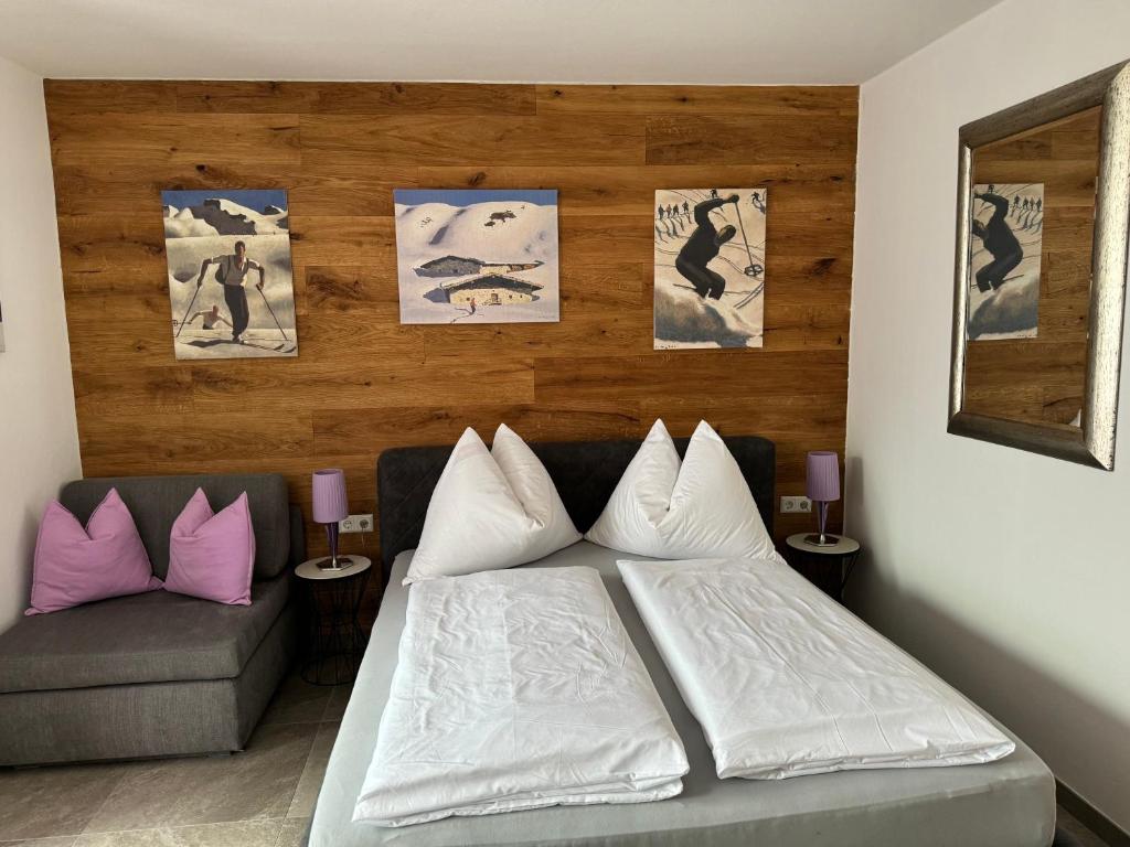 1 dormitorio con 1 cama y 1 sofá y cuadros en la pared en Summit Studio, en Kaprun