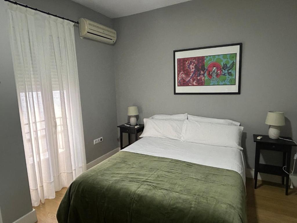 a bedroom with a bed and a window with two lamps at Hostfy Centro, Plaza de la Magdalena in Seville