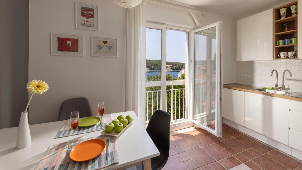 a kitchen and dining room with a table and a window at Vista Porto Apartment in Mali Lošinj