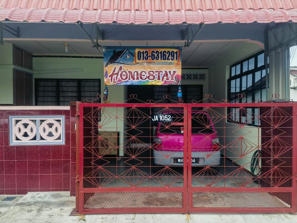 a red gate in front of a house at Urban Escape Homestay Melaka in Merlimau