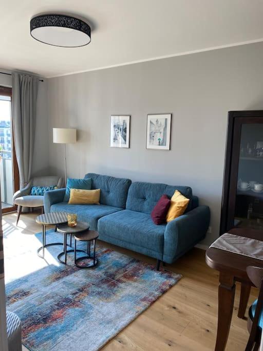 a living room with a blue couch and a table at Cozy City Appartement Warszawa in Warsaw