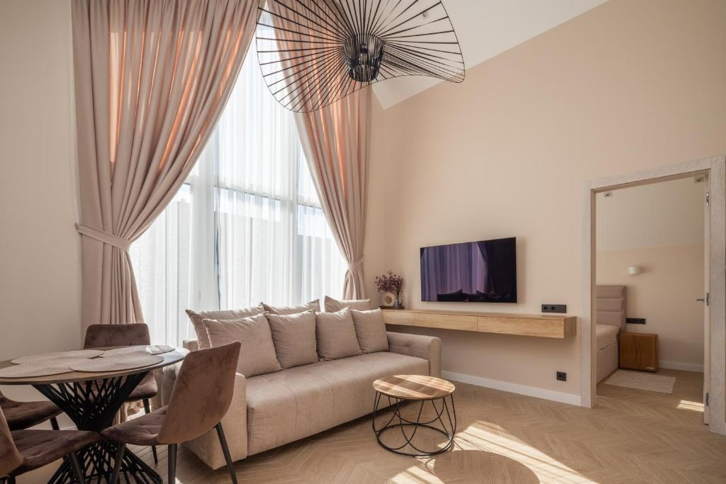 een woonkamer met een bank en een tafel bij LightSummerPalanga in Palanga