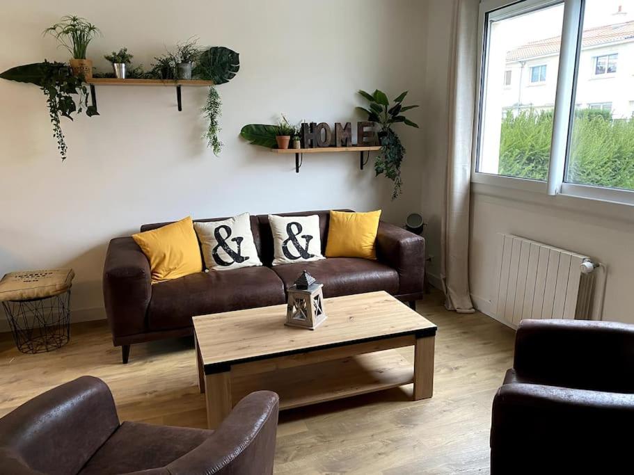 un salon avec un canapé et une table basse dans l'établissement La baumiere 6 personnes, à Cholet