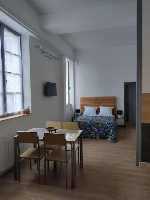 une chambre avec un lit, une table et des chaises dans l'établissement Appartement avec parking privé, à Saumur