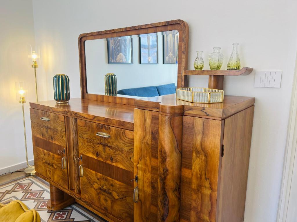 un comò in legno con uno specchio sopra di Dulcamara Boutique Apartments - MAISON DÈCO a Bari