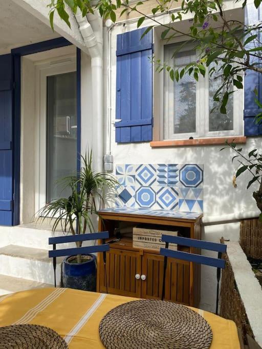 une table et deux chaises devant une maison dans l'établissement maison ville proche plage prophete corniche, à Marseille