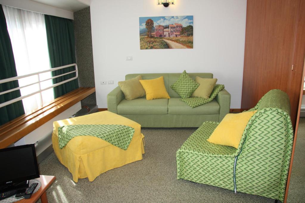 ein Wohnzimmer mit einem Sofa und einem Stuhl in der Unterkunft Albaré Solaria Montana in Marilleva