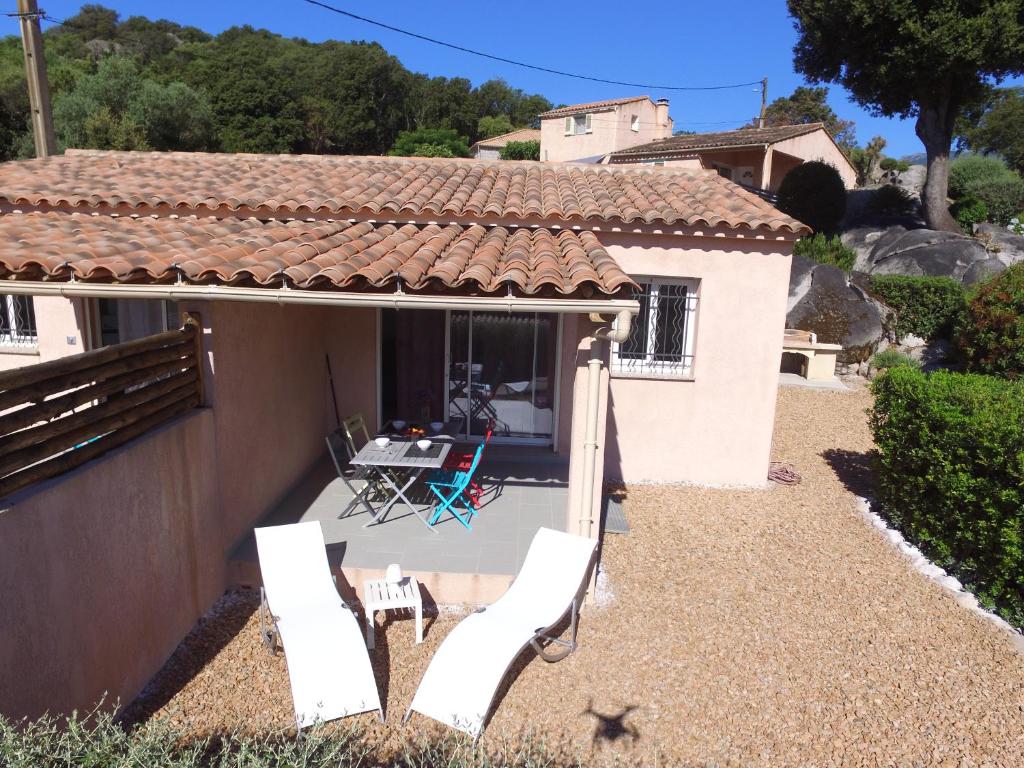 ein kleines Haus mit zwei Stühlen und einer Terrasse in der Unterkunft MINI VILLA entre mer et montagne PALAVESA in Porto-Vecchio