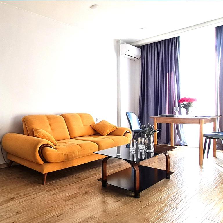 a living room with a couch and a table at Seaside 2-Room 3-Balconies Apt#12 Stunning View in Batumi