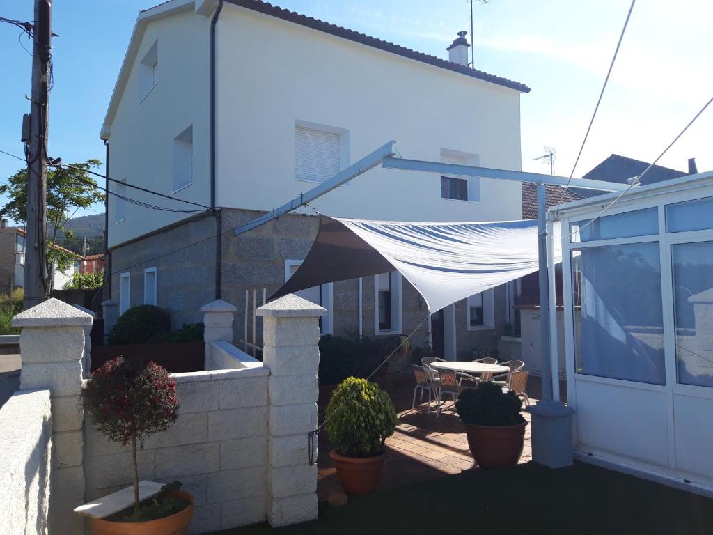 a patio with a white canopy over a white house at Berdullas in Vilagarcia de Arousa