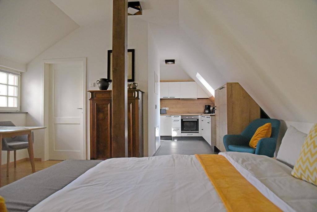 a bedroom with a large bed and a kitchen at Buschschänke Lomnitz - Appartements in Lomnitz