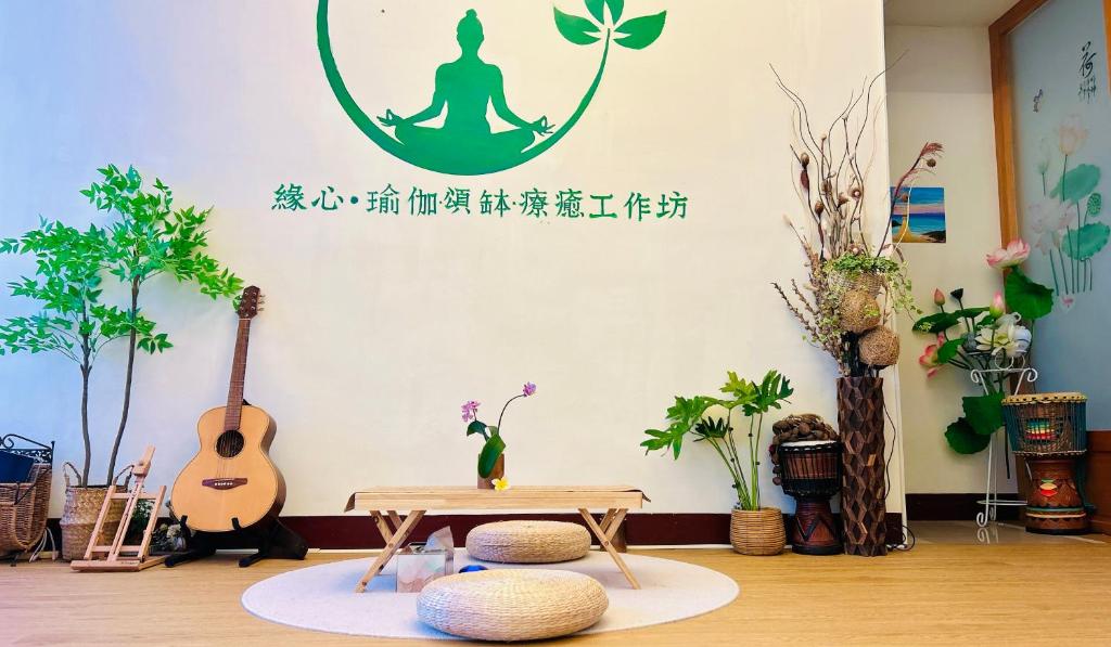 una habitación con una mesa y un mandala en la pared en 緣心 民宿, en Longtan