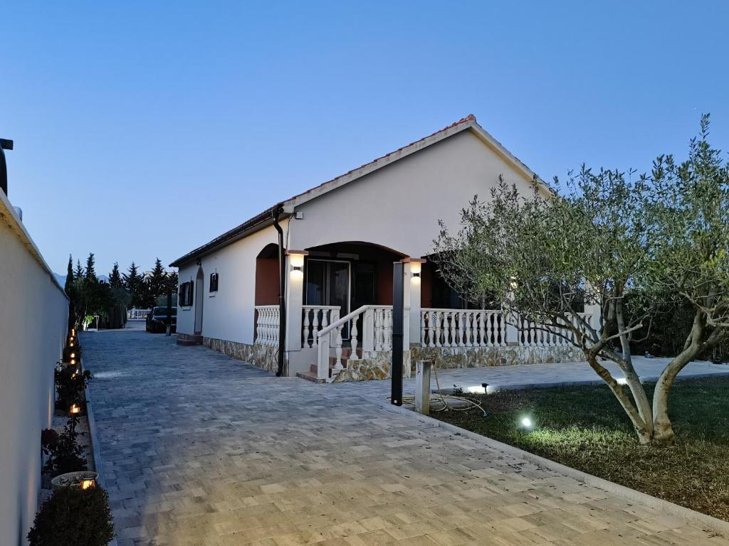 uma casa com um edifício branco e uma entrada em Kuća za odmor Pixie em Vrsi
