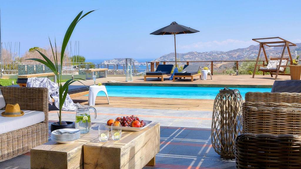 Un patio con mesa y sillas y una piscina. en Casa Blue Villa in Crete, en Agia Pelagia