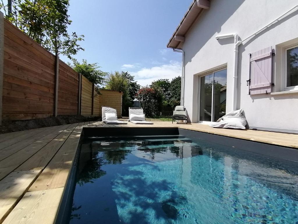 ein Swimmingpool vor einem Haus in der Unterkunft Oïhana Villa & Suites - Piscine chauffée - 4km de la plage in Labenne