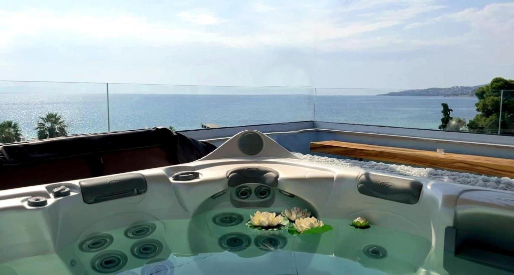 a bath tub with some flowers in the water at Rooftop Loft with Hydromassage in Volos