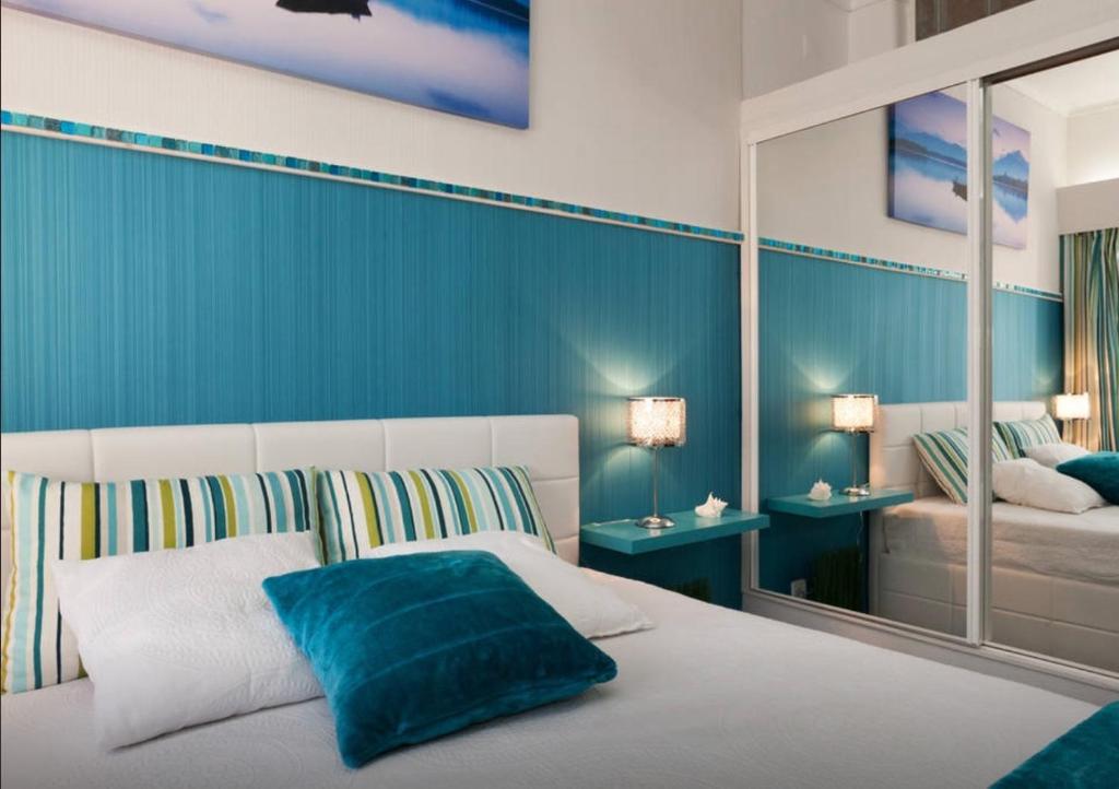 1 dormitorio con 1 cama con pared azul en Casa da Sereia, en Sesimbra