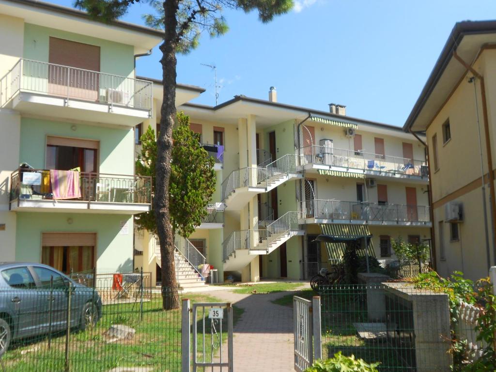 a row of apartment buildings with balconies and a car at Villa Cortina in Rosolina Mare