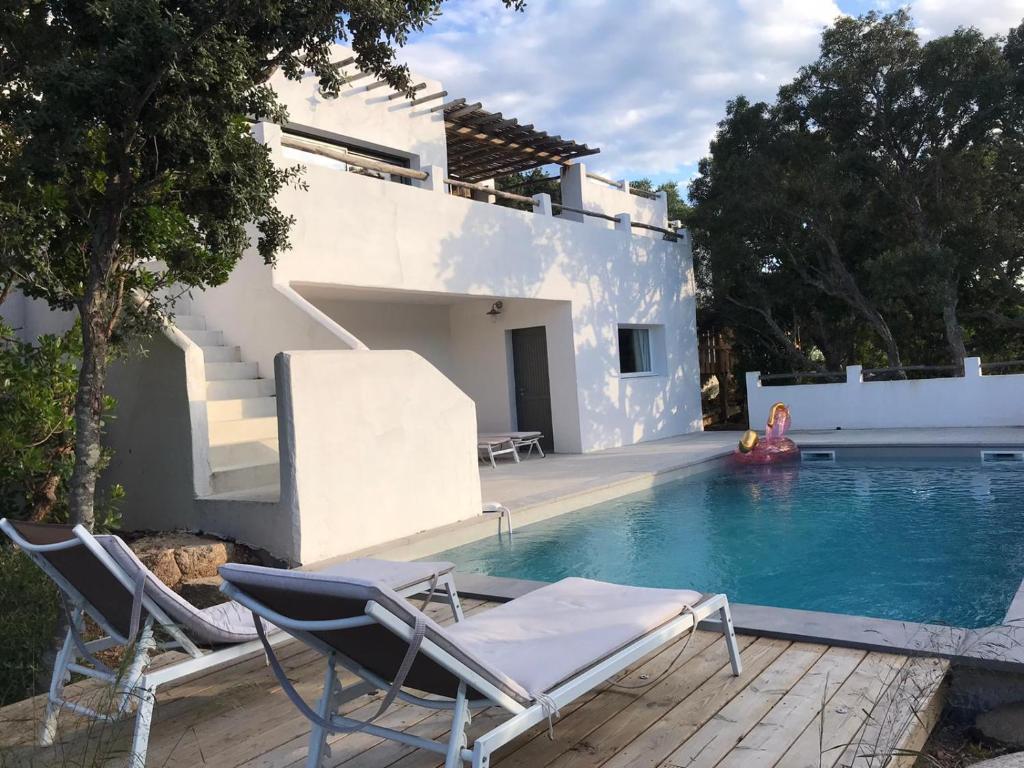 une piscine avec des chaises et une maison dans l'établissement Villa Taru Pinarello, à Mangialla