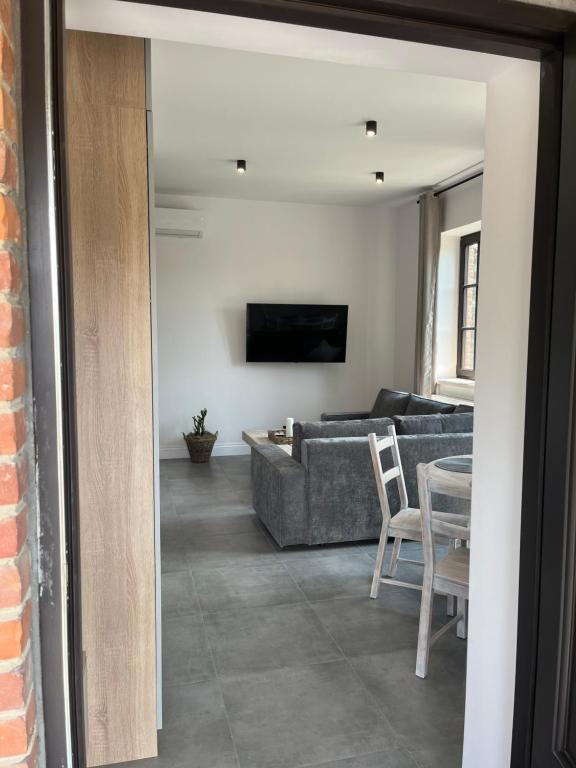 una sala de estar con un sofá y una mesa en Neighbourhood Apartment, en Lublin