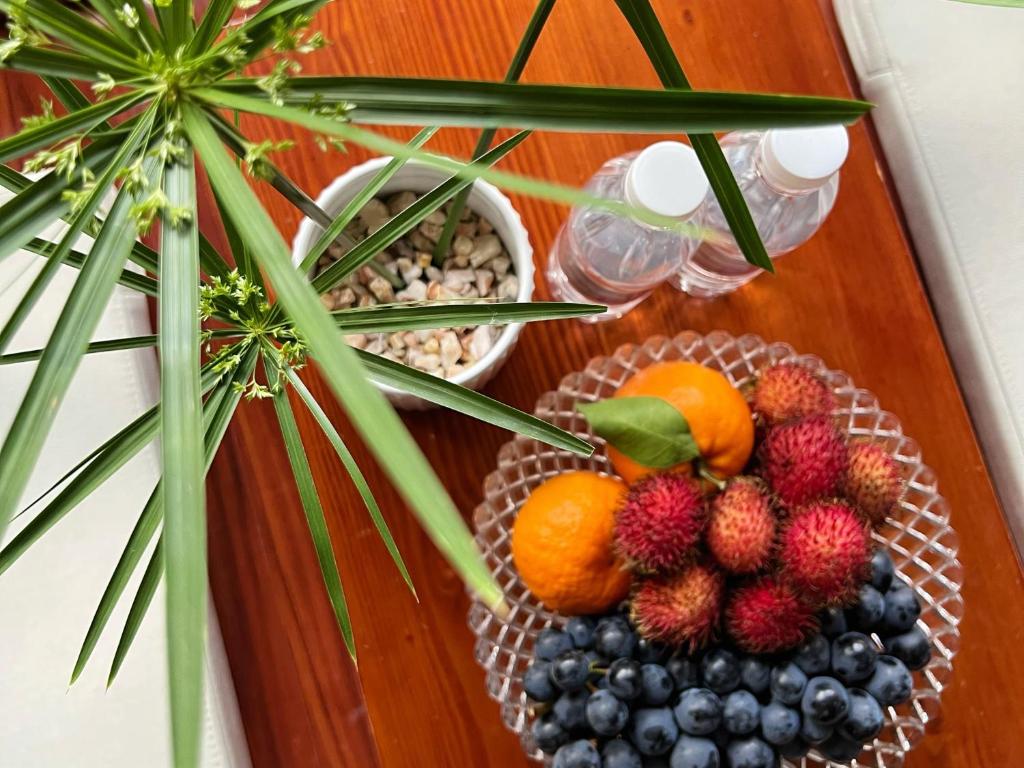 a table with a plate of fruit and a plant at 原乡文苑客栈 in Lijiang
