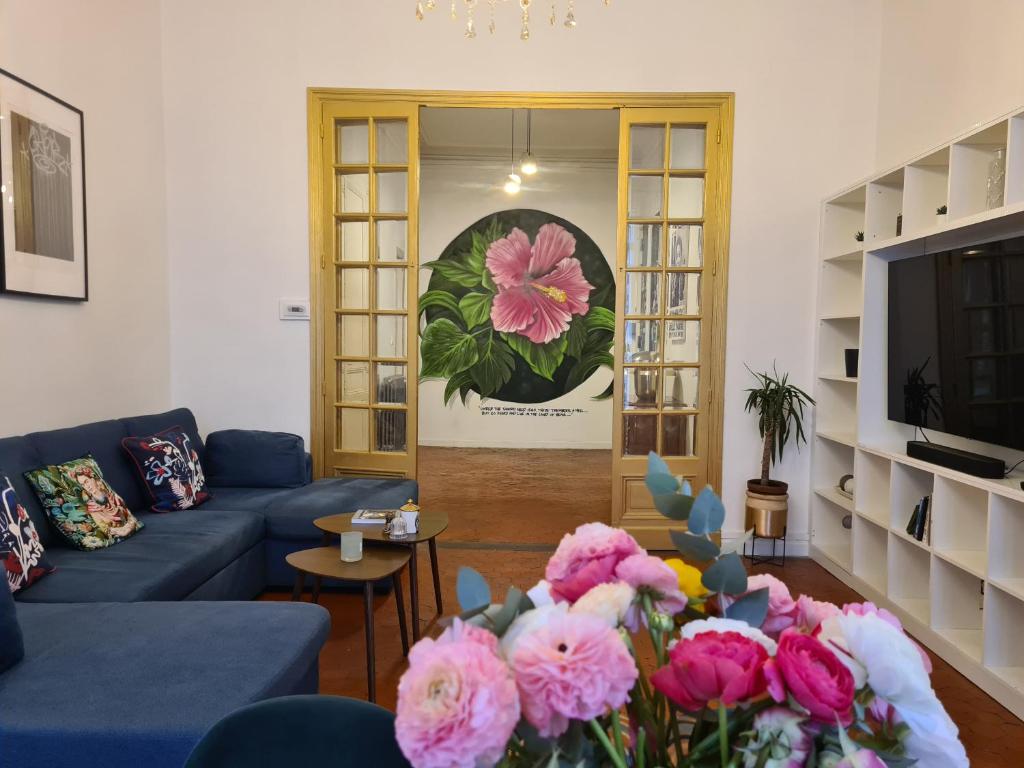 - un salon avec un canapé bleu et des fleurs roses dans l'établissement Labo, à Marseille