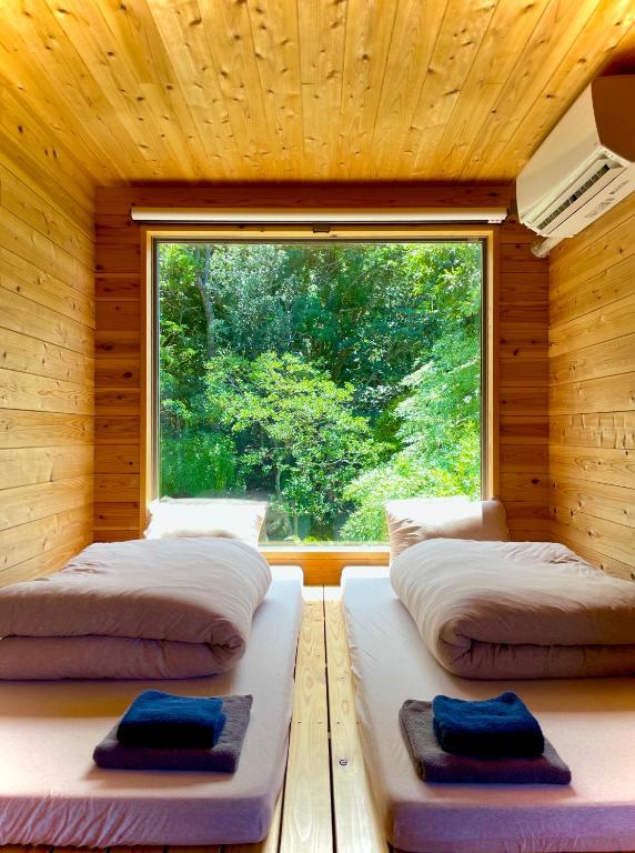 Postel nebo postele na pokoji v ubytování 西海岸オーガニック小麦畑1200坪眺望FarmStayYululu
