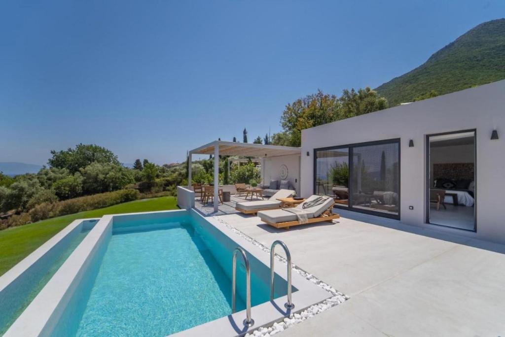 a villa with a swimming pool and a house at Cavalier Suites Nikiana Lefkada AV Properties in Nikiana
