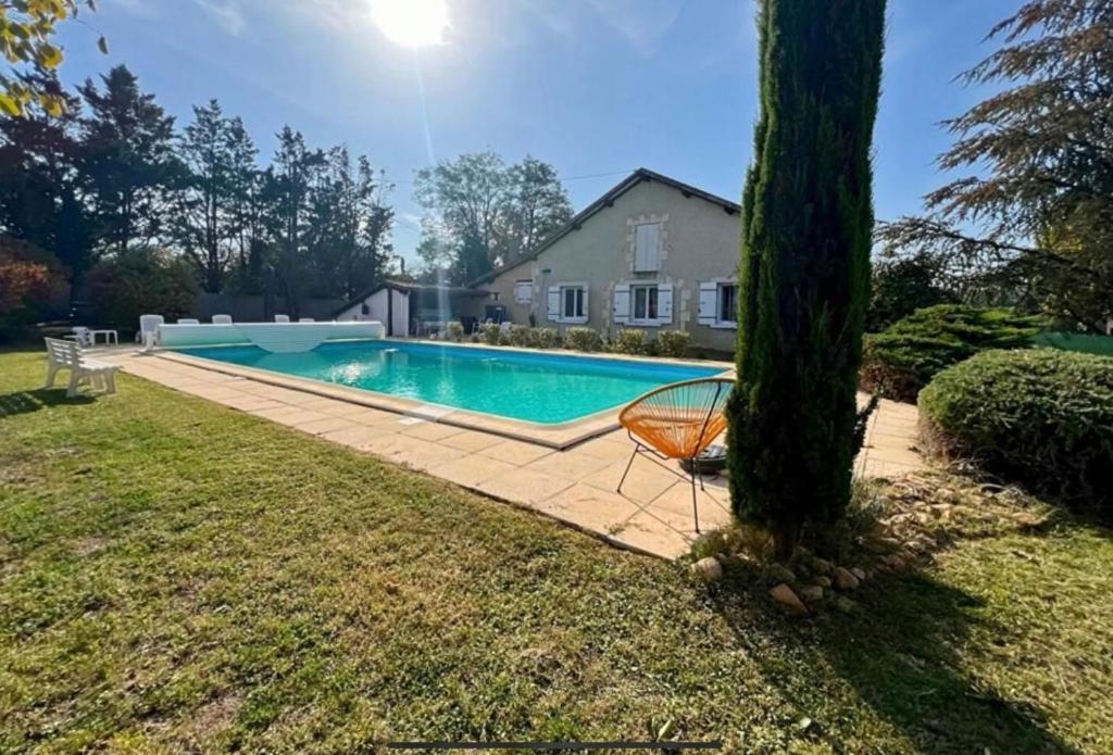 - une piscine avec une chaise à côté d'un arbre dans l'établissement La maison d Ans l Charmante maison en pierres apparentes, à La Forge-dʼAns