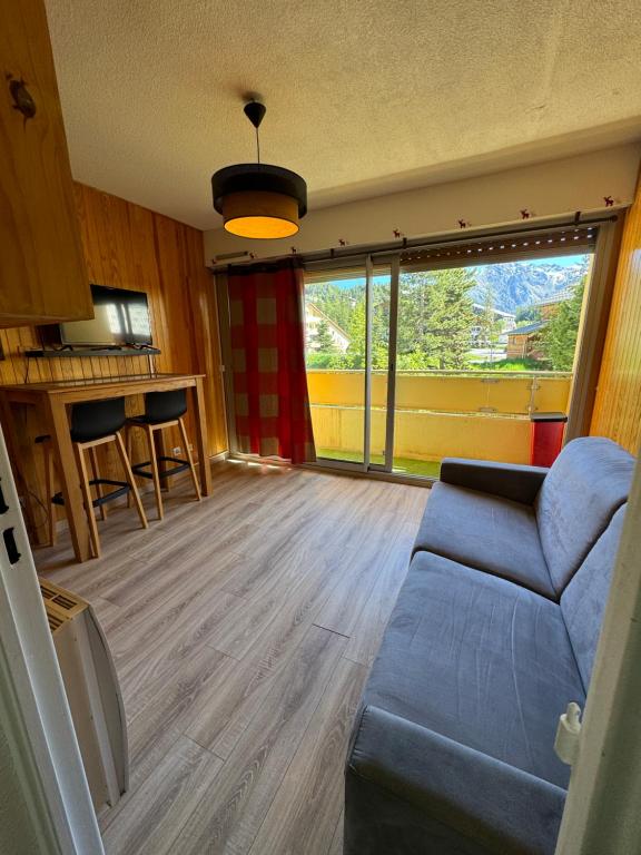 un salon avec un canapé et une grande fenêtre dans l'établissement Studio au cœur d auron 118, à Saint-Étienne-de-Tinée