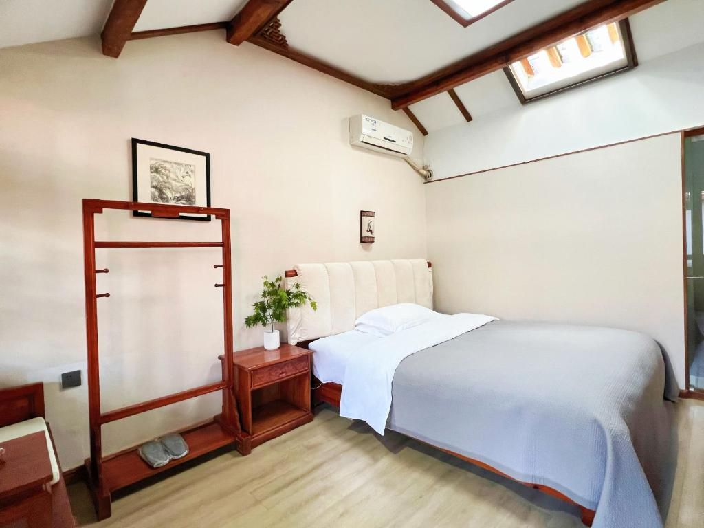 a bedroom with a bed and a mirror at 原乡文苑客栈 in Lijiang