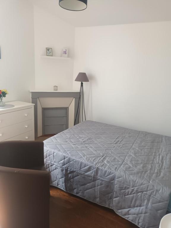 une chambre blanche avec un lit et un bureau dans l'établissement Appartement f3, à Cormeilles-en-Parisis
