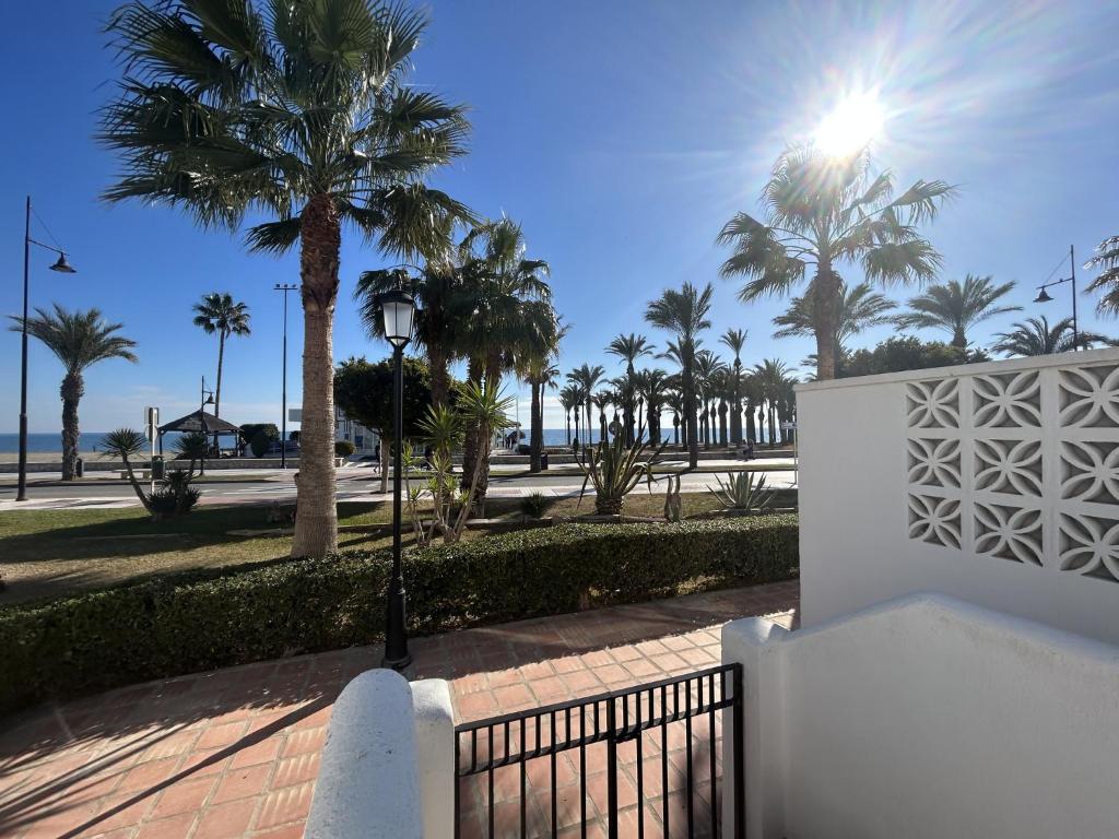 a street light next to a fence with palm trees at Casa de playa los Alamos Andra in Torremolinos