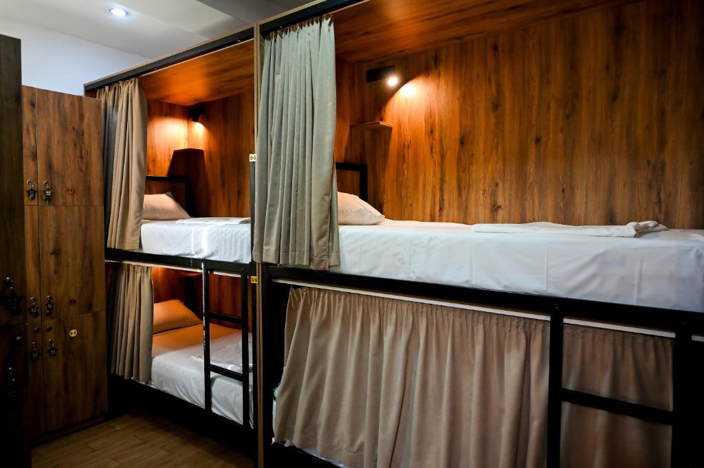 two bunk beds in a room with wooden walls at StarHostel in Kutaisi